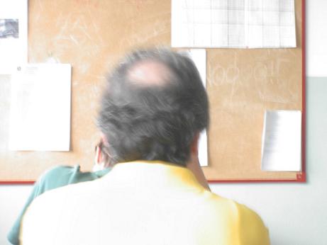 Immagine di un professore ripreso di spalle durante un interrogazione.